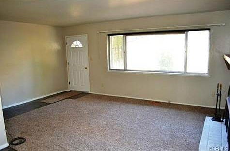 The living room has a cozy fireplace, new carpet and paint and a