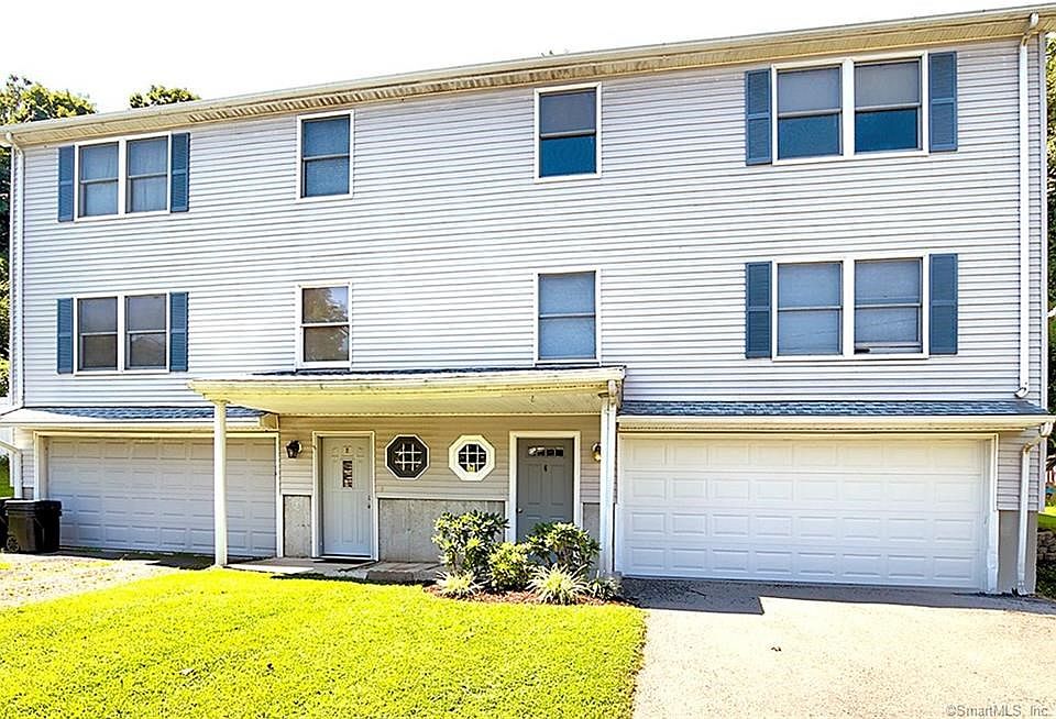6 Adanti is the half-duplex on the right with the gray front door. On the lower (walk-in) level is a two car garage, the utility room (with the furnace) and tiled hallway.