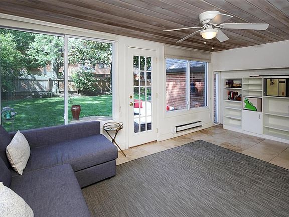 Family room overlooking brick patio and fenced yard.