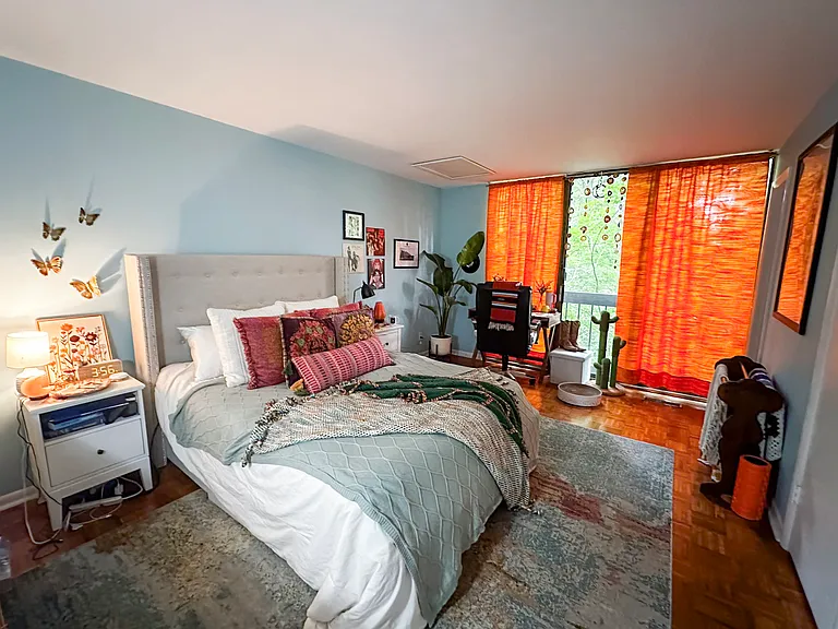 Primary bedroom with wood parquet flooring, floor-to-ceiling windows overlooking the woods (includes en-suite bathroom and walk-in closet)