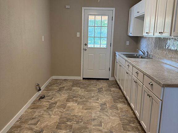 Kitchen with new cabinets, flooring, sink and backsplash.