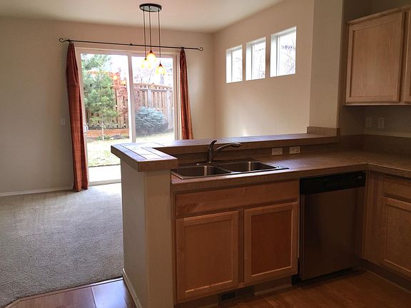 Kitchen with dishwasher view to dining area, patio and fenced back yard
