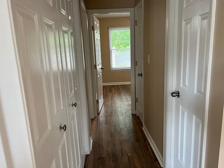 Hallway with Laundry on the left with motion sensor light switch. Common Bathroom on the right.