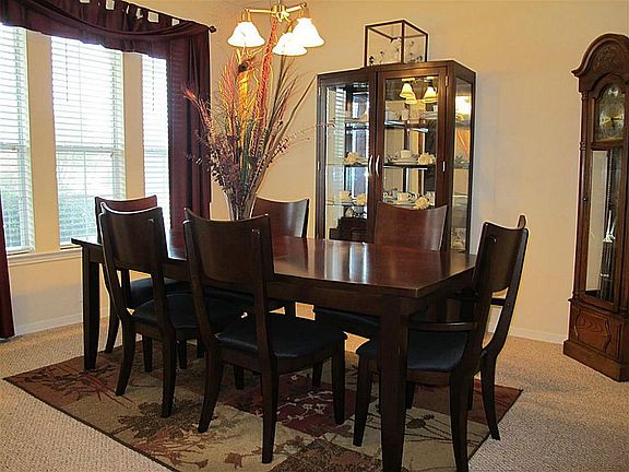 Elegant formal dining boasts rich crown millwork, 2" blinds, lovely curtains, neutral carpet, and el