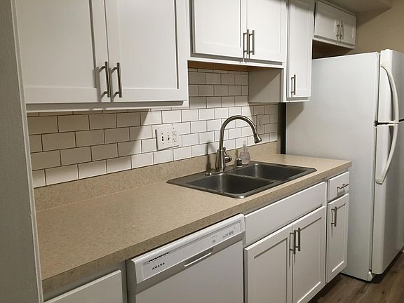 Galley kitchen with disposer, ice maker, new dishwasher, new counter, and new cabinets.