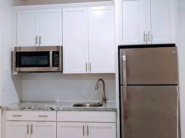 Sleek, modern kitchenette designed for efficiency. Includes a high-end multi-function microwave/convection oven and premium Refrigerator with an ice maker, perfect for preparing simple, delicious meals in your own private living space.