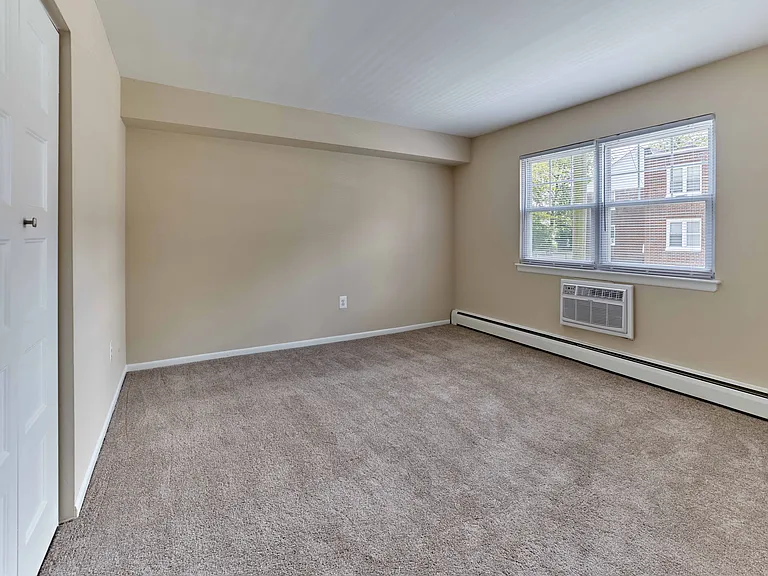 Spacious bedroom with plush carpet and natural light at 42 West Apartments in Merchantville, NJ