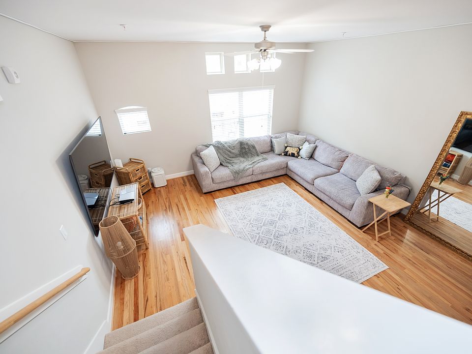Spacious living room with high ceiling, hardwood floor and abundant natural light