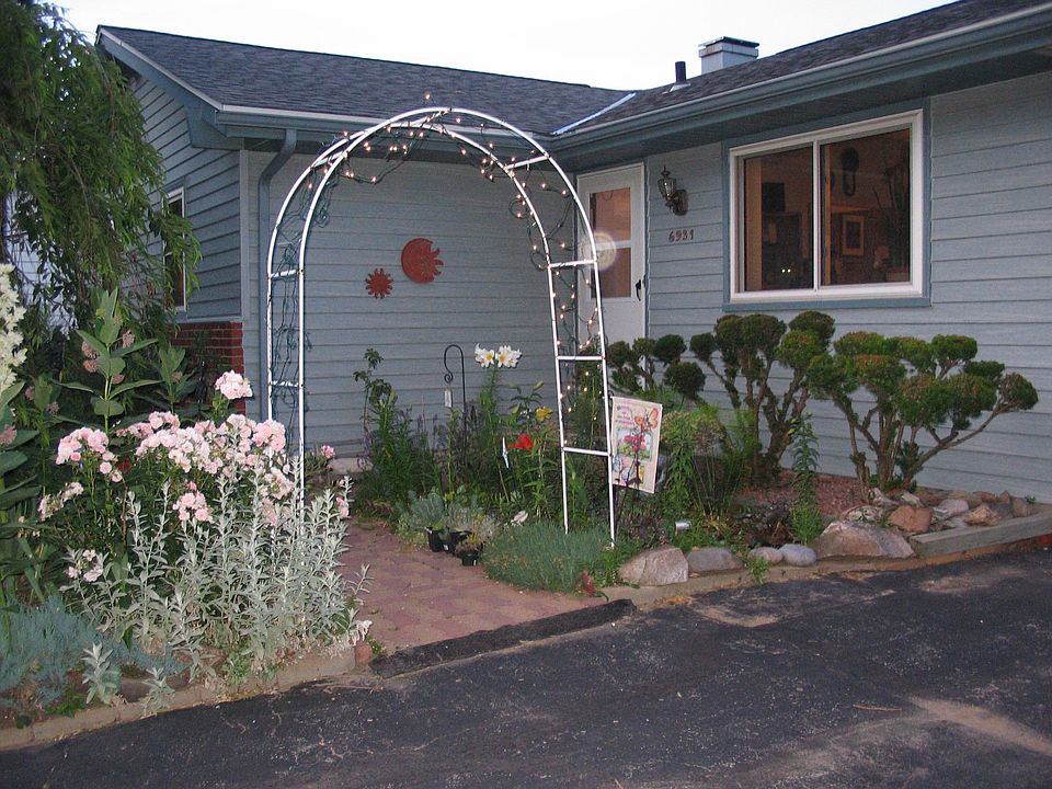 front of house w/welcoming gardens