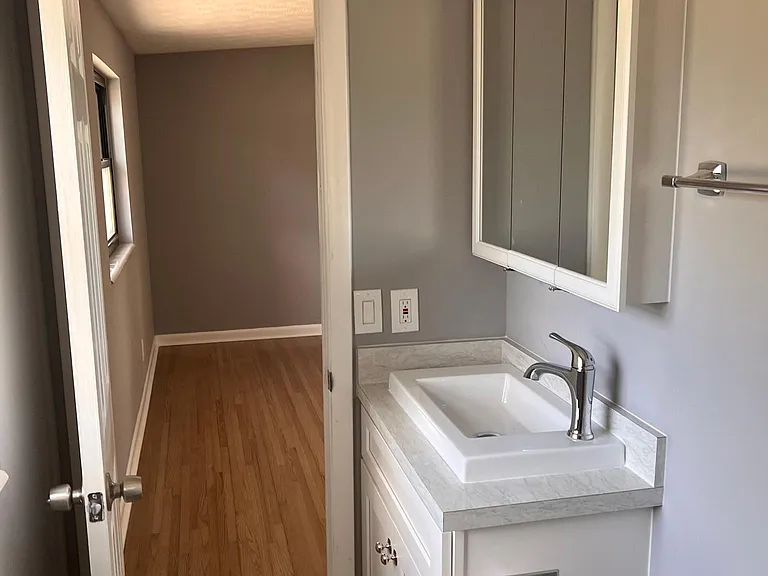 Master bath with newly tiled shower and tile floors, new vanity' and light fixtures with sinks and toilet.