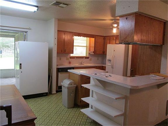 This kitchen has a freezer, breakfast bar and shelving for your whatnots