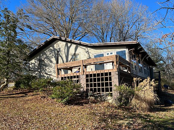 Right rear of house and deck. All season heated/cooled sunroom spans the entire length of the rear.