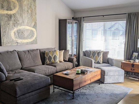 Bright main living area with vaulted ceiling and fan/light.
