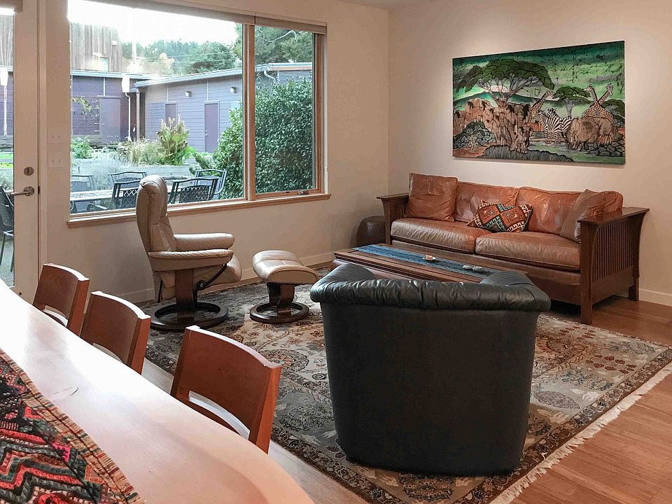 Living room with view through window to patio and garden area.