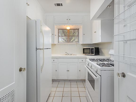 Kitchen with gas stove/oven, refrigerator and microwave.