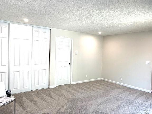 Large living room with new recessed lighting, door to hallway provides privacy, new flooring and new paint