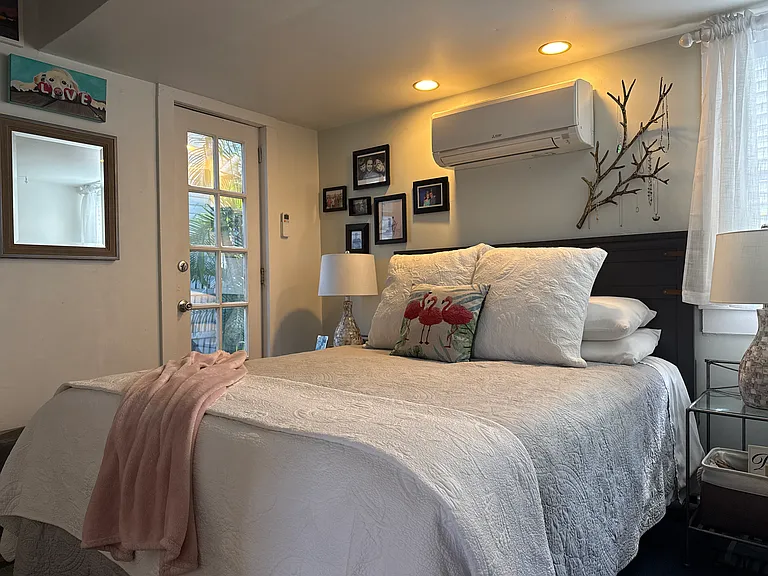 Master bedroom with queen bed that leads out to backyard sitting area.