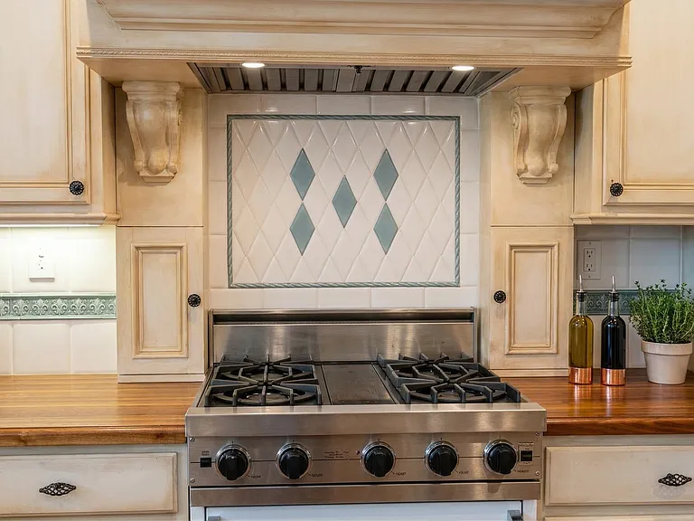 Gourmet kitchen featuring Viking gas range, custom hood, and rich wood countertops