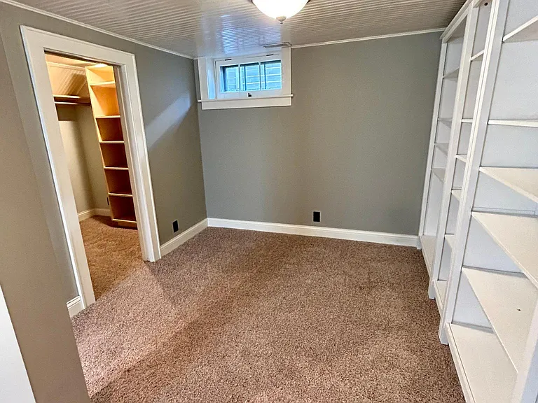 Bookshelves compliment this extra space which is connected to the walk-in closet.
