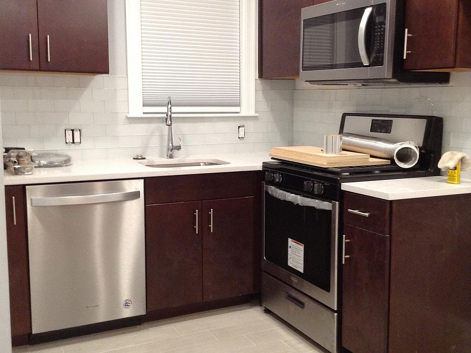 Brand New Fully appliance kitchen with stainless steel appliances dishwasher, gas stove, built in microwave, refrigerator (not shown) and tile floor.