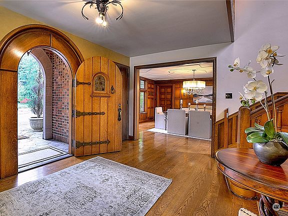 The front door has an impressive rounded, original oak door, with an original stained-glass window that can open to the outside to greet guests.>