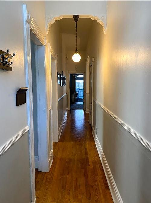 Hallway entrance fro front door leads to kitchen and deck. To the left is the living room, then the 2nd large bedroom. On the right is a large walk in closet and alcove perfect for a desk. Victorian light fixtures and details throughout the home.