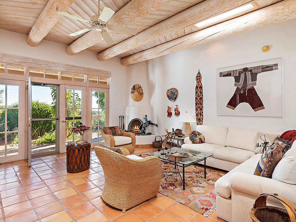Living area with kiva fire place and large windows with access to the private patio