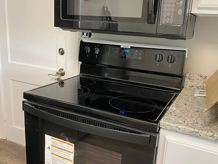 New microwave and smooth cooktop stove. Granite countertops and tons of newly painted white wood cabinetry.