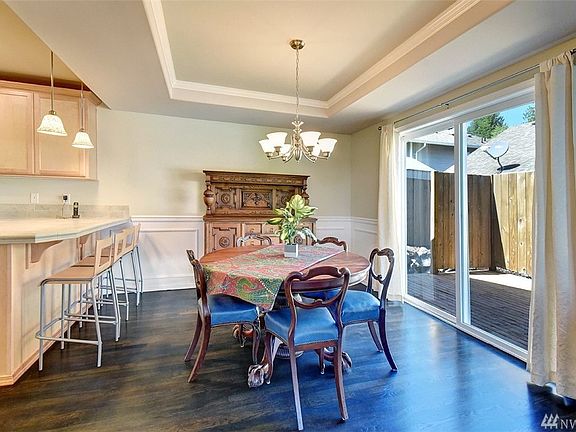Dining room features coved ceiling with crown molding and opens to private deck through sliding glass doors. Chair railing and shadow boxes also are included in the millwork package.