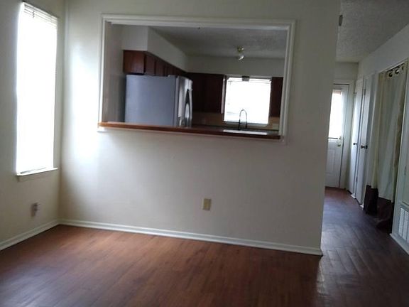 This is the entry living room that looks into the kitchen area. There is a fireplace on the window side of the wall. There is 3 windows on the one side wall in the living room.