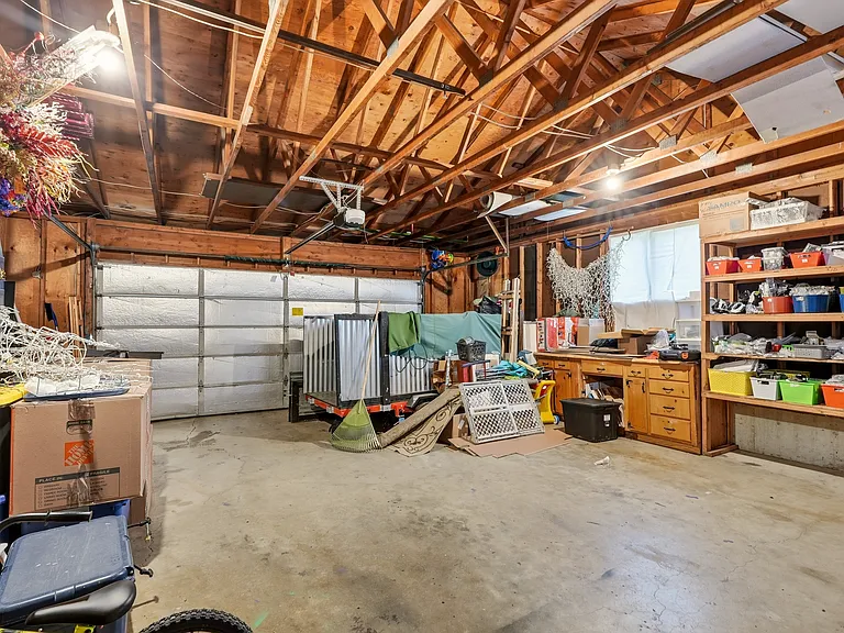 attached two-car garage has access to the lower level rec room and paved area behind house
