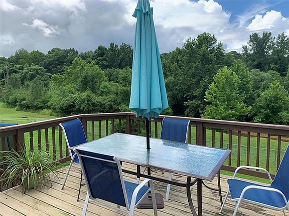 Deck overlooking fenced in back yard and beautiful scenery.