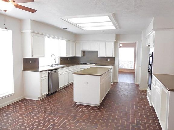 Large gourmet kitchen with a new double-oven, abundant cabinets, new refrigerator, and counter space plus a huge island