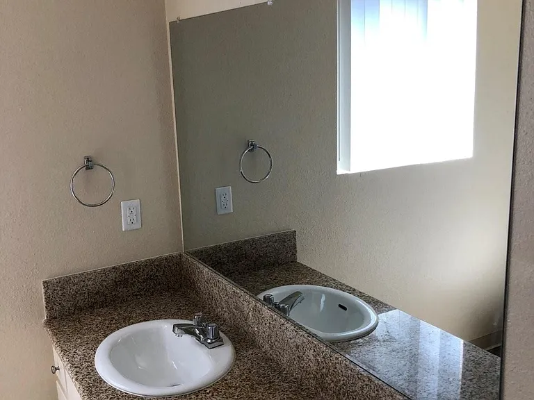 Bathroom with large vanity and great natural lighting at Plaza Verde Apartments in Escondido, California.