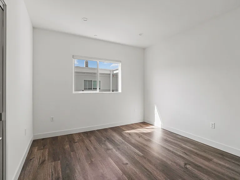 Bedroom with Mirrored Closet, Vinyl Flooring, and Window