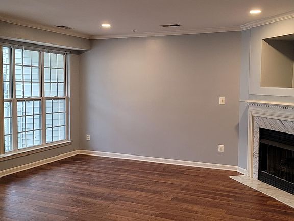 Living room with brand new floor, just painted walls and dropped ceiling lights.