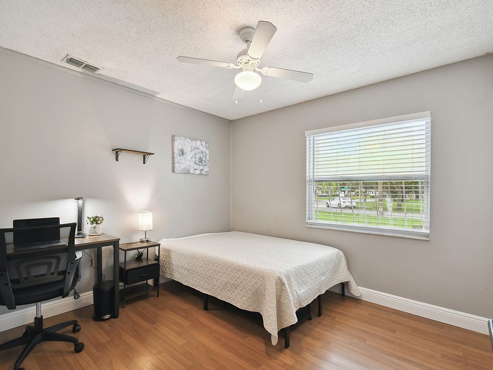 Full size cozy bed, with end table, light and storage container under the bed.