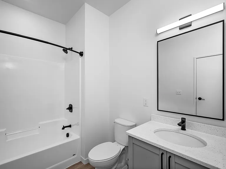 Modern bathroom with sleek fixtures, a large mirror, and a stylish white and black color scheme. Modern bathroom with sleek fixtures, a large mirror, and a stylish white and black color scheme.