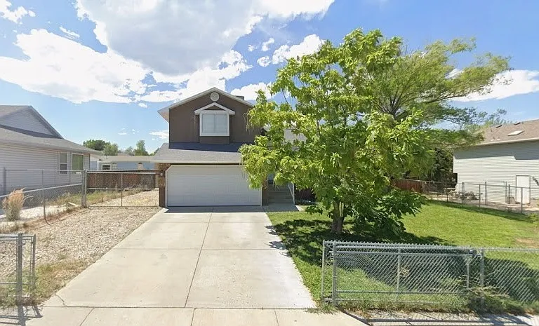 Gravel extends to backyard for additional parking. Gate to closed driveway entrance.