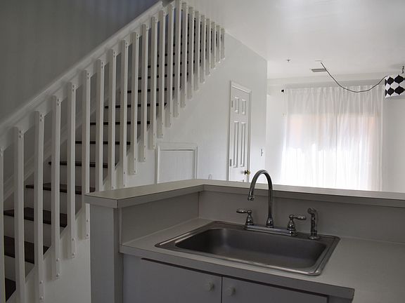view of stairs and dining/living area from standing in the kitchen