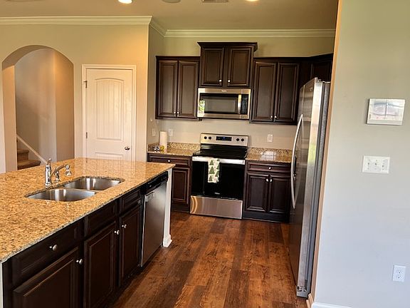 Stainless steel appliances included: microwave, electric range, dishwasher, refrigerator, and sink with garbage disposal