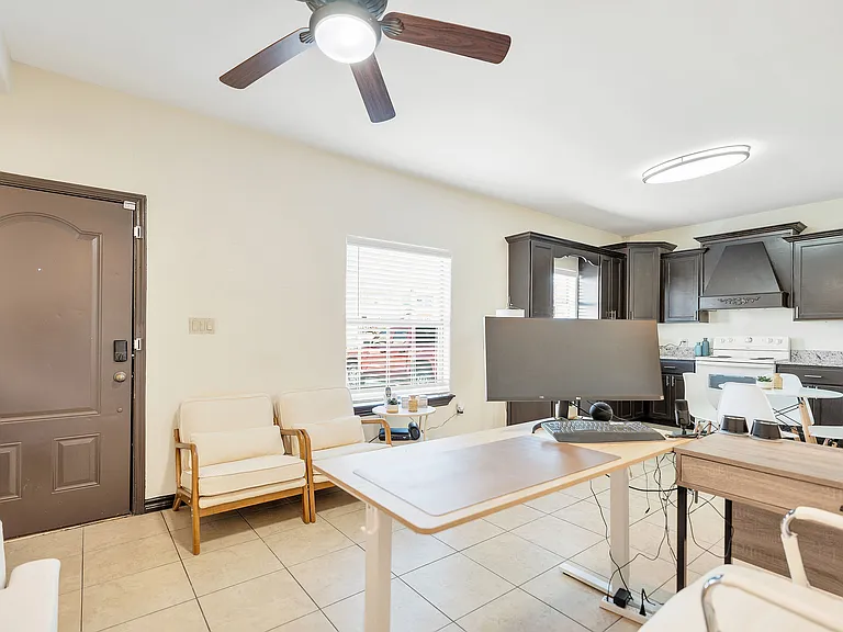 Kitchen area with a desk and ceiling fan, showcasing the interior of Merida Vista Apartments in Laredo, Texas