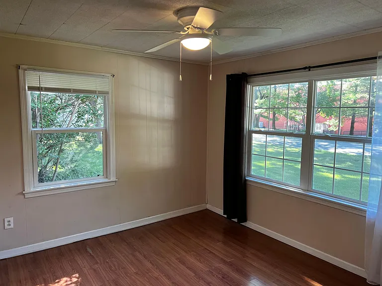 Bedroom number one with ceiling fan, newer windows and closet.