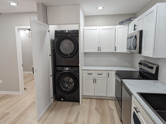 Kitchen showing washer and dryer closet open