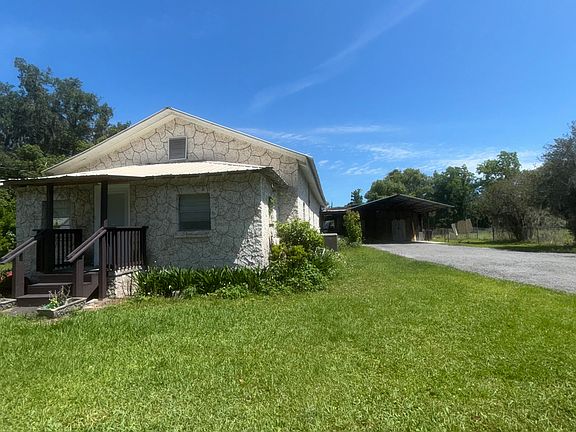 a view of clean driveway and carport, that leads into huge workshop and laundry room.