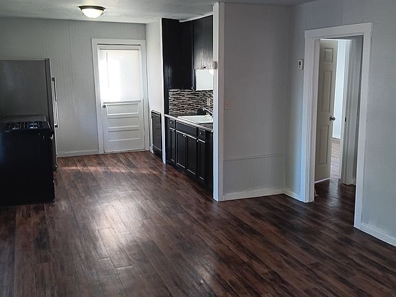 The living room and kitchen are located in a common space. There is a dishwasher located near the sink.