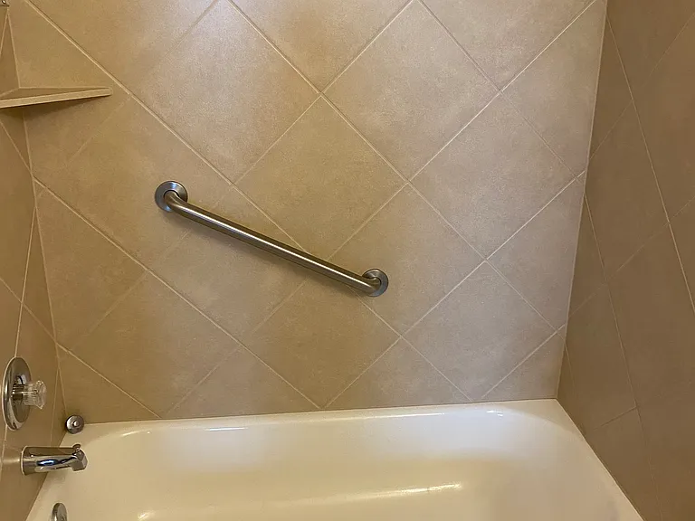 Hall bathroom with Bathtub / shower combo/ grab bar and shelf/ tile