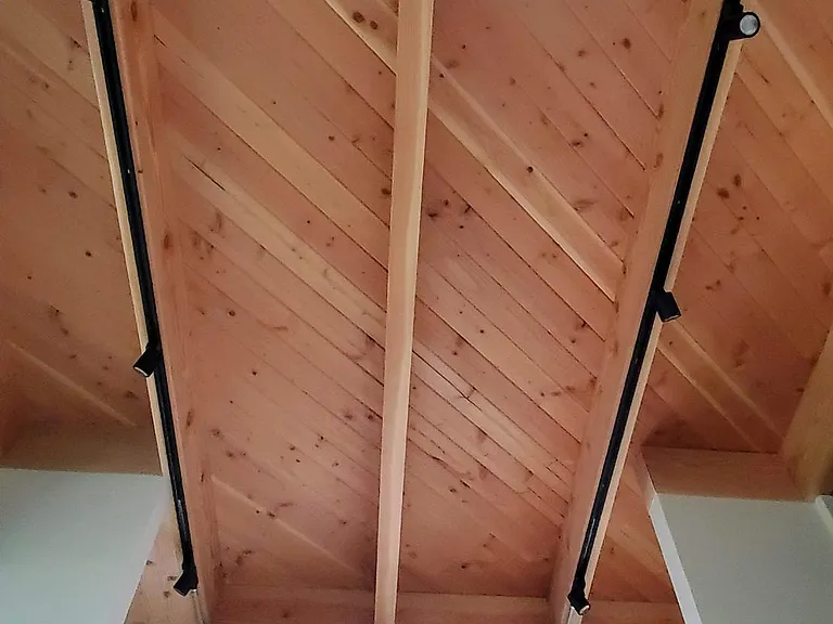 Exposed beam and T&G Fir bedroom ceiling and dimmable track lighting.