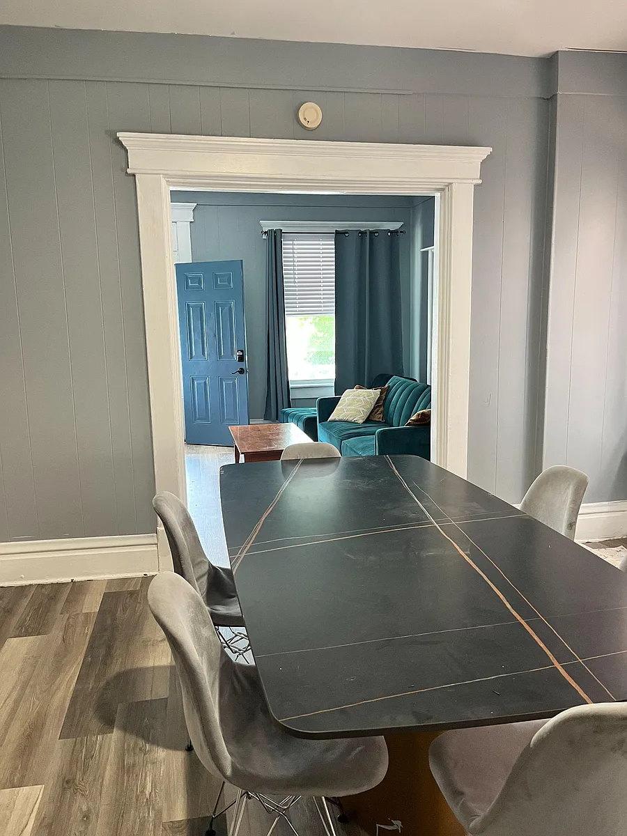 Photo 2 of 6 - N 22nd St - Columbus, OH Dedicated dining area with a large table and seating, opening to a living space with a window and durable flooring. - N 22nd St