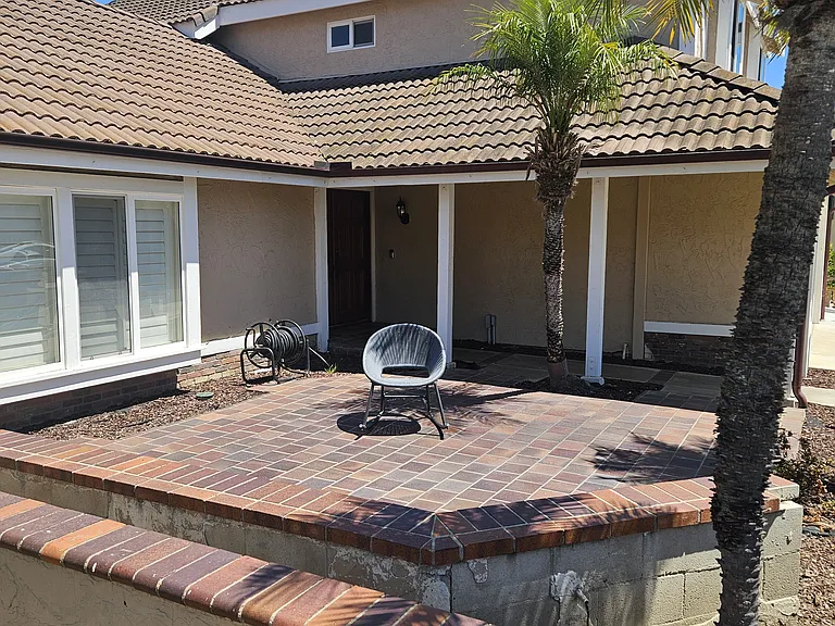 Front brick patio and seating bench faces west sun set